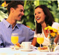 Photo of a happy couple sitting at breakfast outside on a deck in Niagara